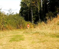 Raunchy young chick pees down the slope of a hill