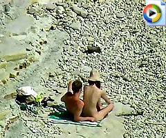 Young nude couple rejoice on a sunny beach